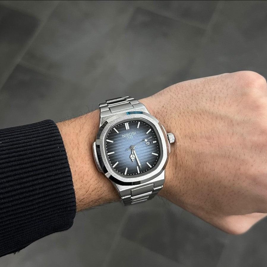 Homem usando o relógio Nibosi Astronaut 41mm com pulseira de aço inoxidável e design moderno.