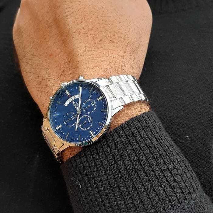Relógio Nibosi Masculino 2309 Com Pulseira de Aço Inoxidável Prata e Visor Azul no Pulso de um Homem