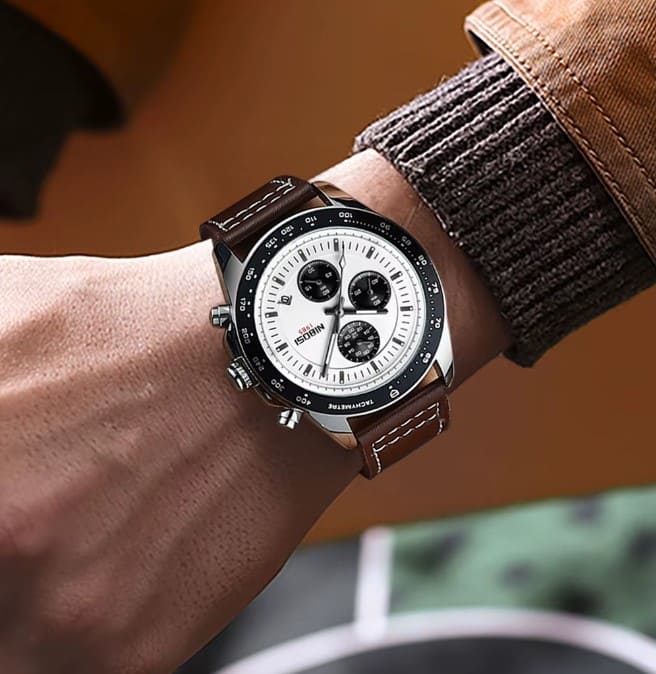 Detalhes do visor do relógio masculino Nibosi com pulseira de couro marrom com cronógrafo preto e visor branco no pulso de um homem