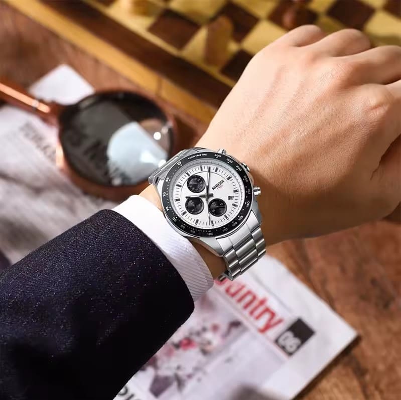Homem usando o Relógio social masculino elegante Nibosi Nimbus com pulseira de aço inoxidável prata e visor branco 44mm e cronógrafo funcional, destacando sua elegância