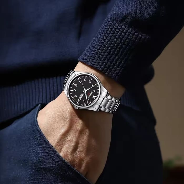 Relógio Nibosi masculino Syncro com pulseira de aço inoxidável prata e visor preto no pulso de um homem