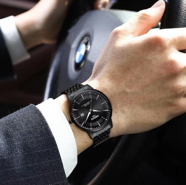 Relógio Nibosi Masculino com pulseira em aço inoxidável preta com visor preto no pulso de um homem