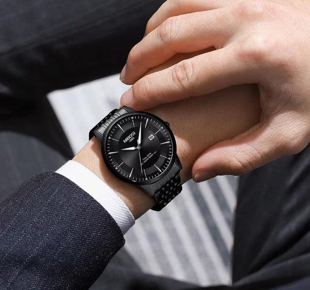 Relógio Nibosi Masculino com pulseira em aço inoxidável preta com visor preto no pulso de um homem