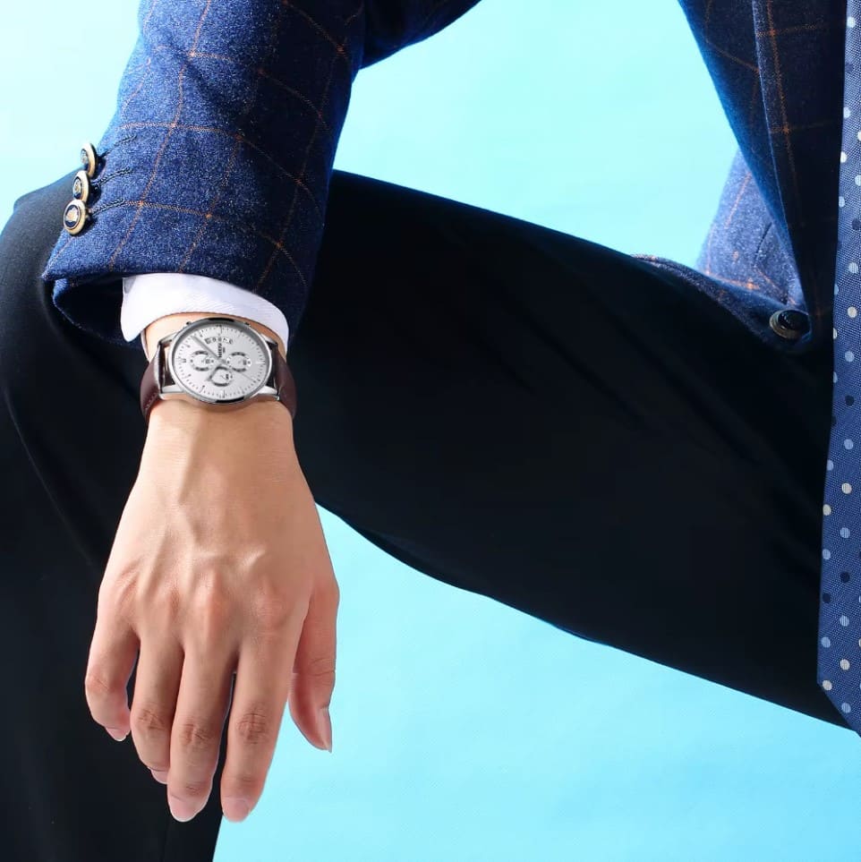 Relógio Nibosi Clássico Masculino com pulseira de couro no pulso de um homem, social e elegante.
