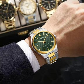 Relógio Nibosi Minimalista Masculino de Aço Inoxidável Prata e Dourado Com Visor Verde no Pulso de um Homem