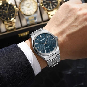 Relógio Nibosi Minimalista Masculino de Aço Inoxidável Prata Com Visor Azul no Pulso de um Homem