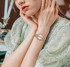 Mulher usando o relógio feminino Nibosi Belle pulseira e caixa rosé com visor rosé
