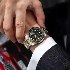 Homem usando o Relógio automático masculino Nibosi Majestic com pulseira em aço inoxidável prata com detalhes em dourado e visor preto