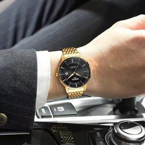 Relógio Nibosi Masculino com pulseira em aço inoxidável dourado com visor preto no pulso de um homem