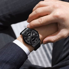 Relógio Nibosi Masculino com pulseira em aço inoxidável preta com visor preto no pulso de um homem