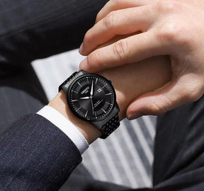 Relógio Nibosi Masculino com pulseira em aço inoxidável preta com visor preto no pulso de um homem